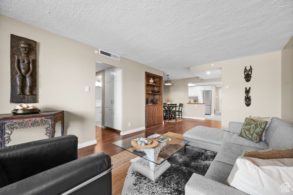 Living room featuring a textured ceiling and hardwood / wood-style flooring