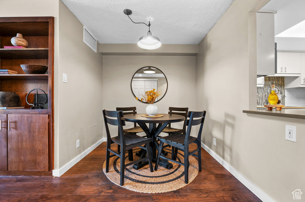 Dining room featuring wood-type flooring and a textured ceiling