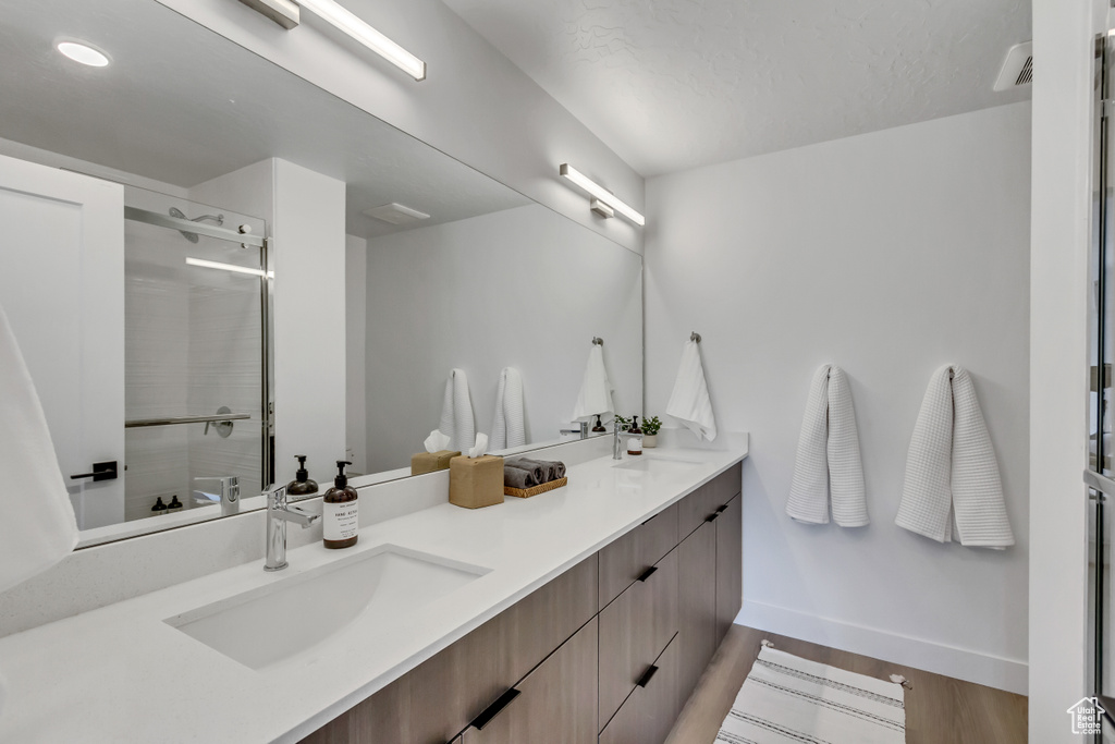 Bathroom with dual vanity and hardwood / wood-style floors