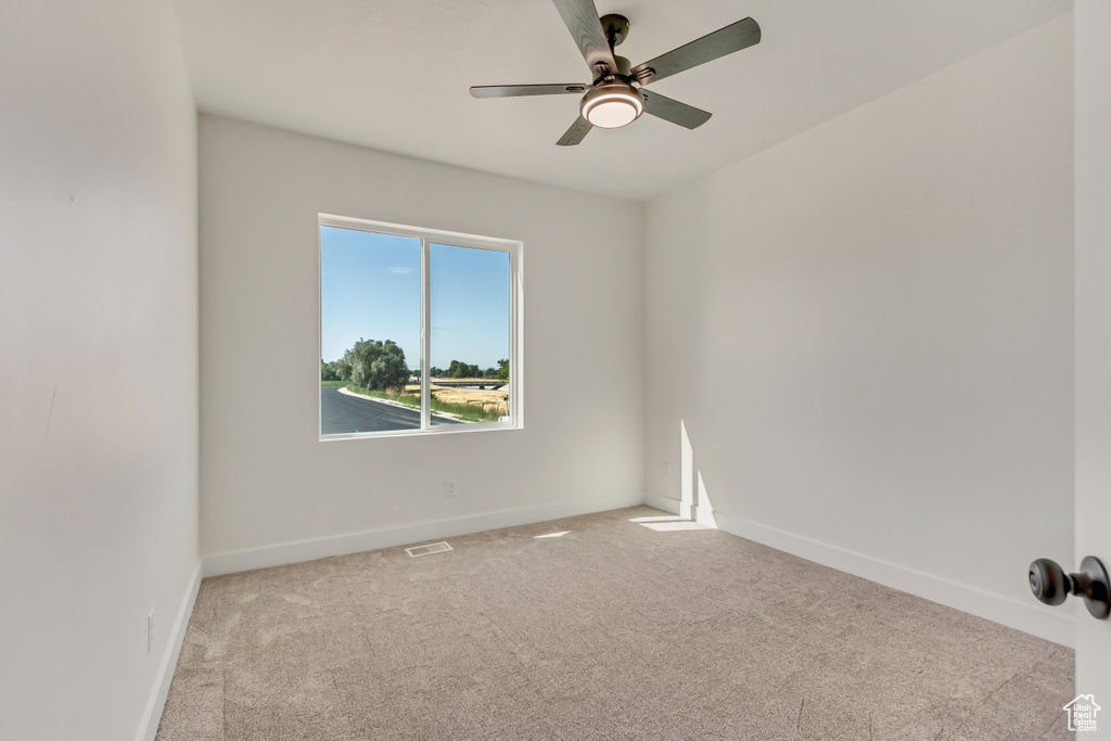 Unfurnished room with light colored carpet and ceiling fan