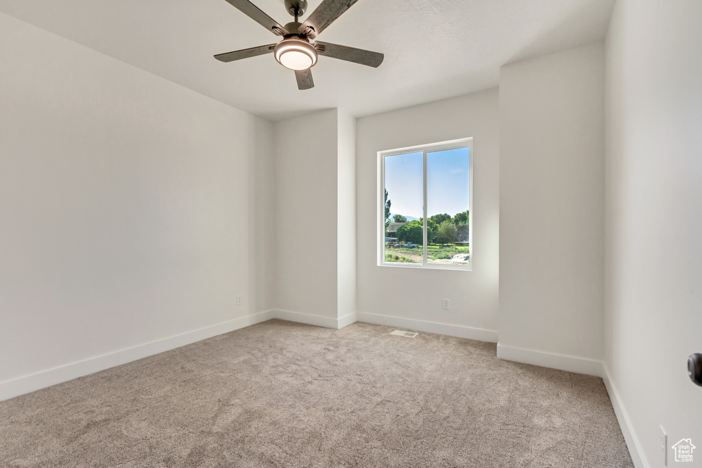 Carpeted empty room with ceiling fan