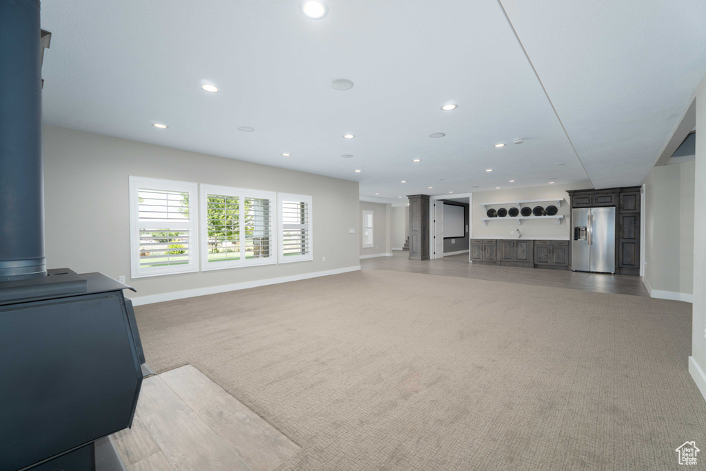Living room featuring a wood stove and light colored carpet