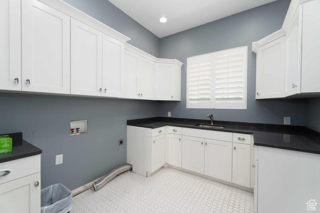 Laundry room featuring sink, cabinets, hookup for a washing machine, and light tile patterned floors