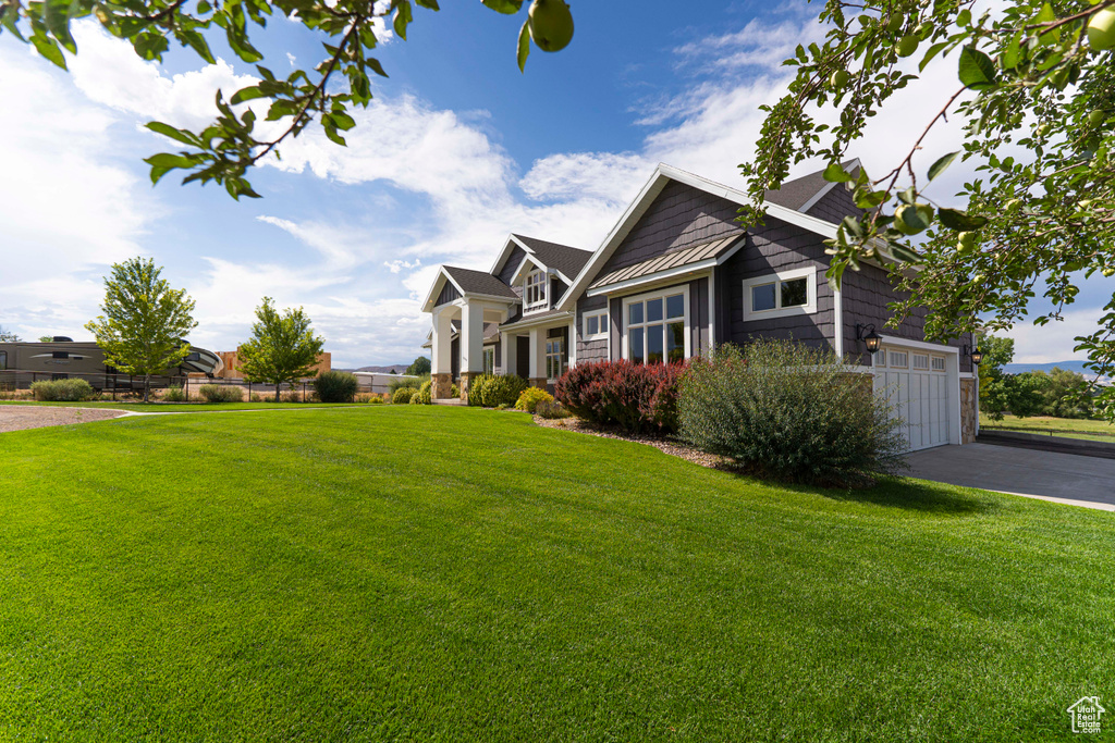 View of front of property featuring a garage and a front lawn