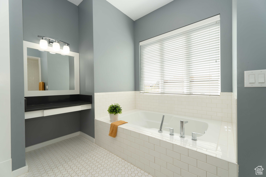 Bathroom with tile patterned flooring and tiled bath