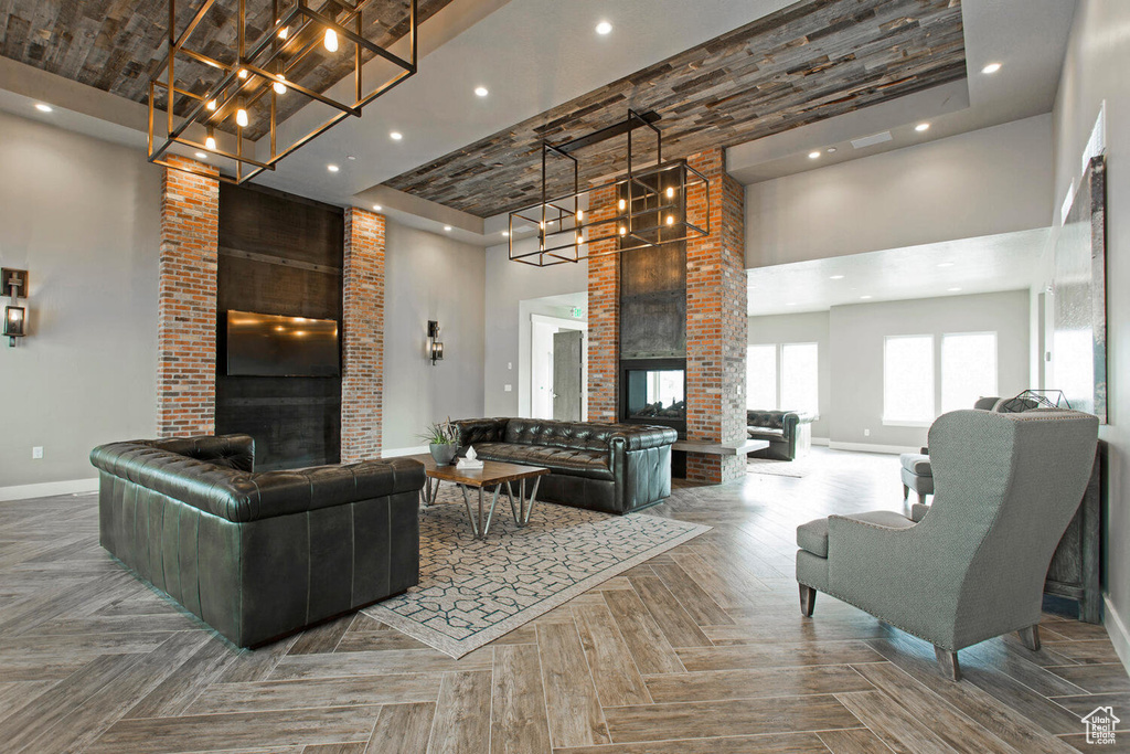 Living room with a high ceiling, brick wall, a multi sided fireplace, and parquet floors