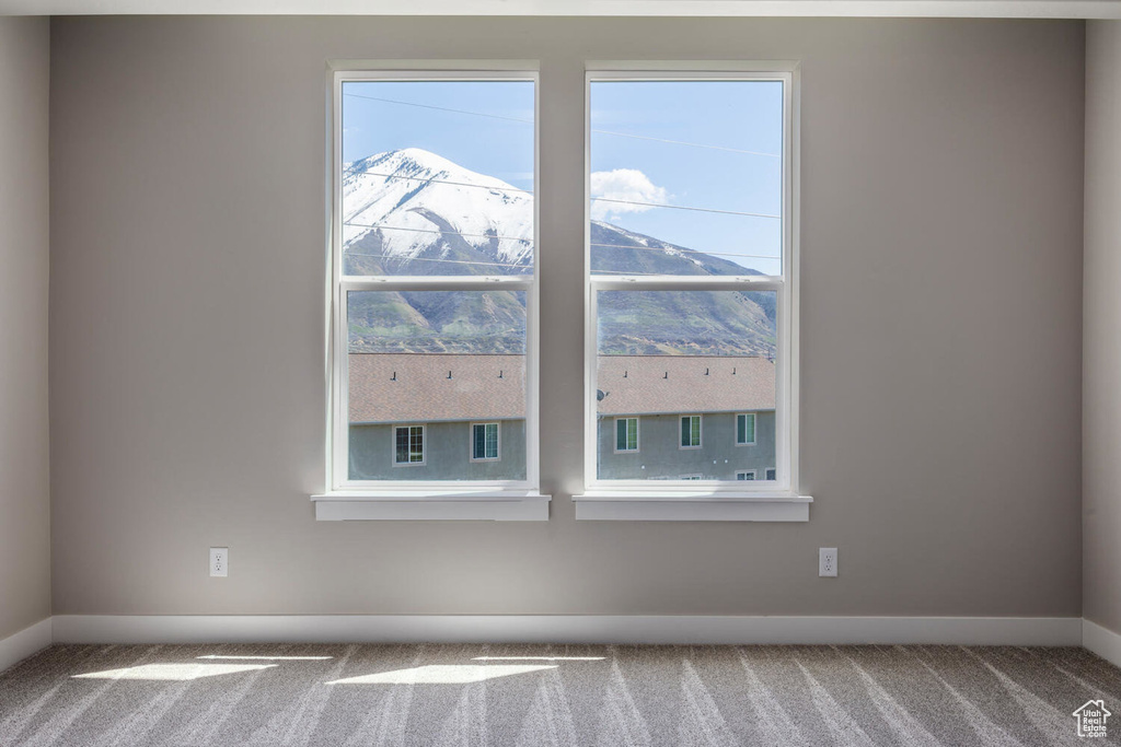 Carpeted spare room featuring a mountain view and plenty of natural light