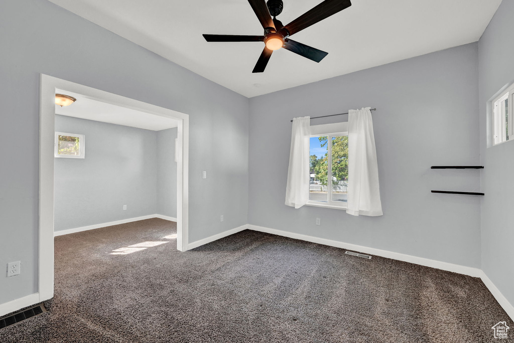 Carpeted empty room with ceiling fan