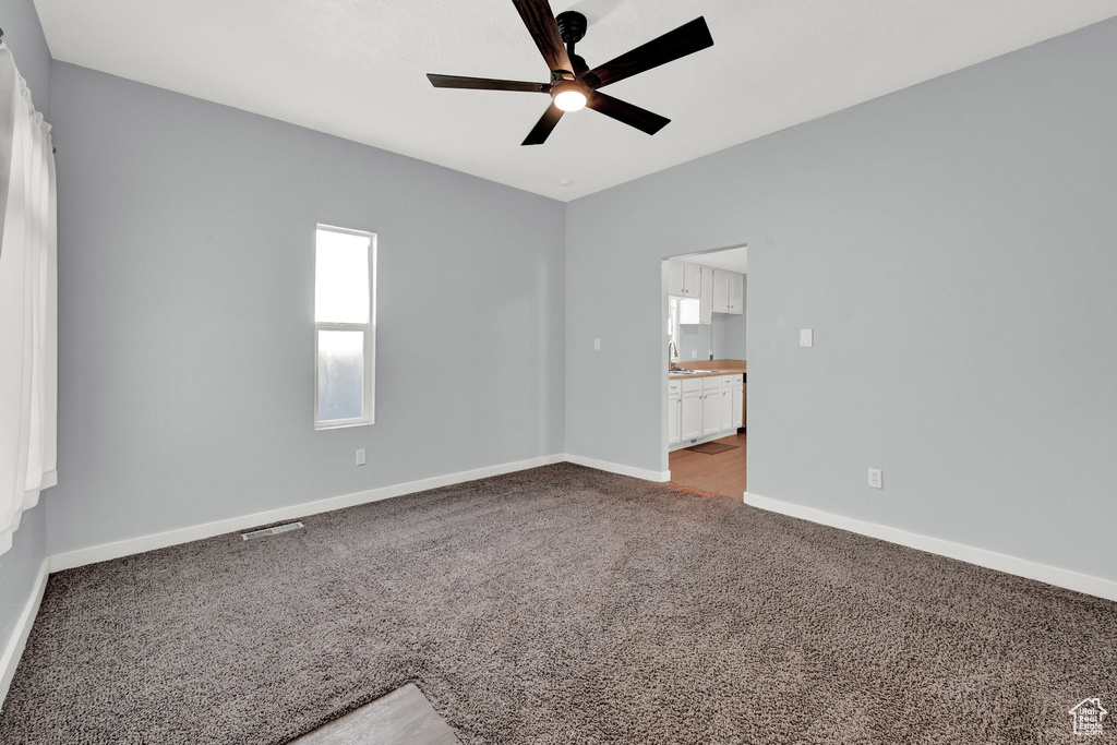 Carpeted empty room with sink and ceiling fan