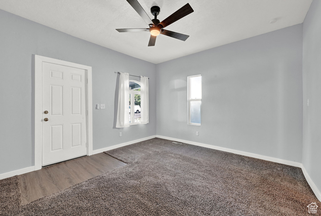 Empty room featuring ceiling fan and carpet floors