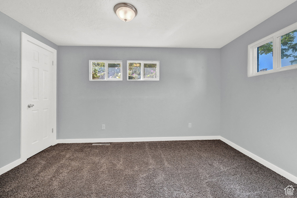 Spare room featuring a textured ceiling and carpet flooring