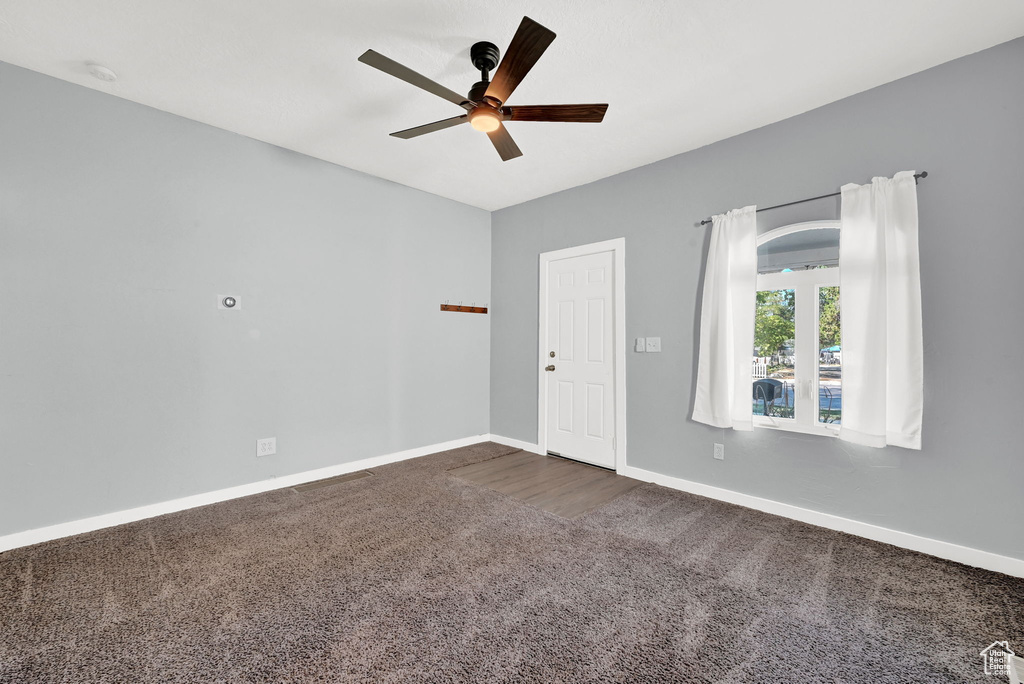 Carpeted empty room with ceiling fan