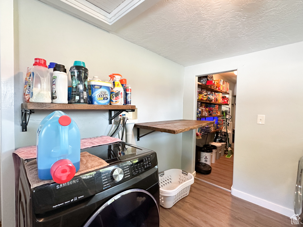 Clothes washing area featuring a textured ceiling and hardwood / wood-style floors