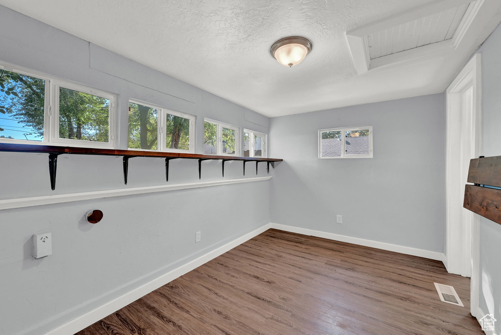 Unfurnished room with a textured ceiling and hardwood / wood-style flooring