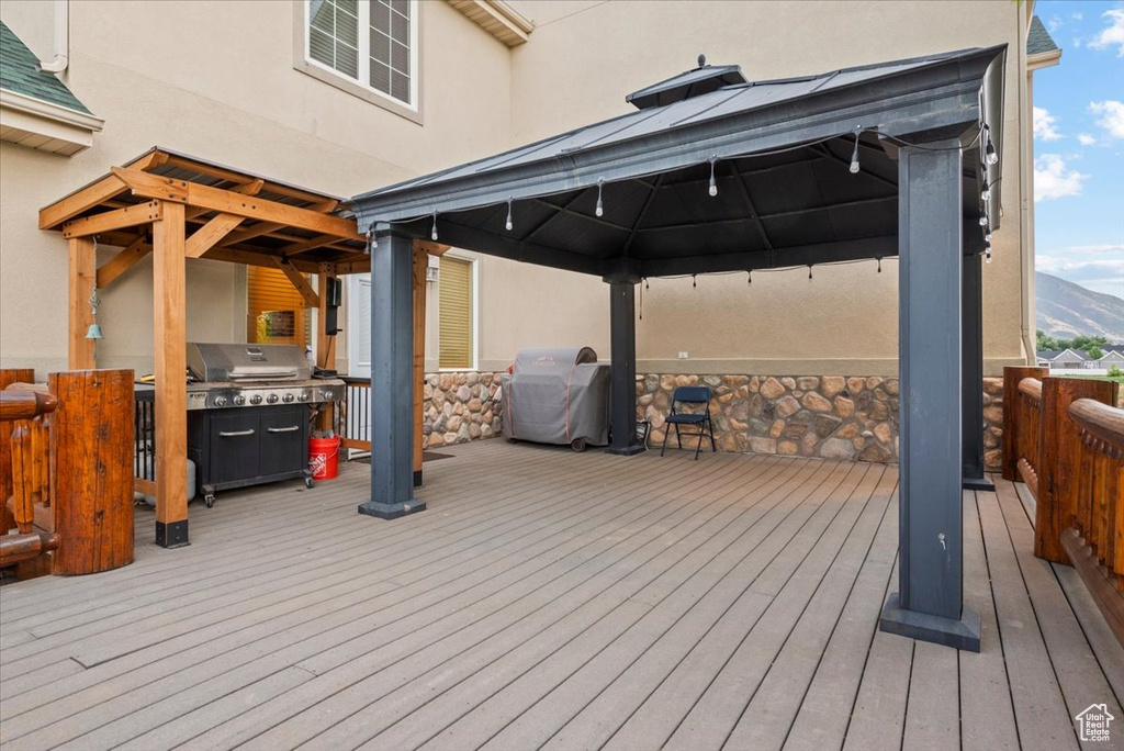 Wooden terrace with grilling area, a mountain view, and a gazebo