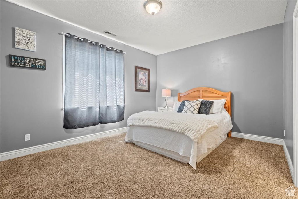 Bedroom featuring a textured ceiling and carpet flooring