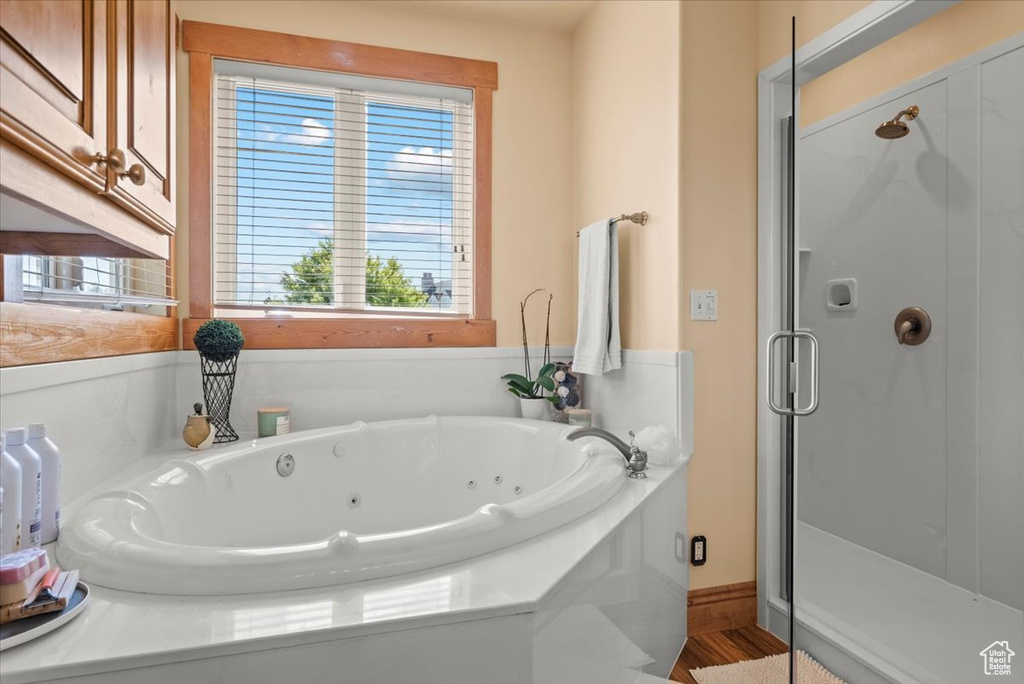 Bathroom with wood-type flooring and independent shower and bath