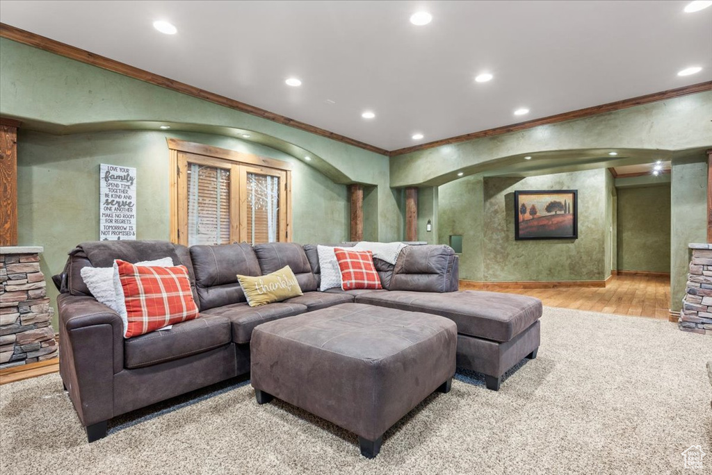 Home theater room with ornamental molding and hardwood / wood-style flooring