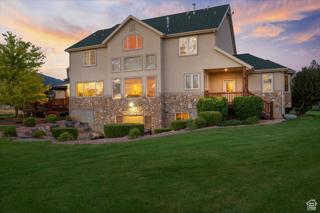 View of front facade featuring a deck and a yard