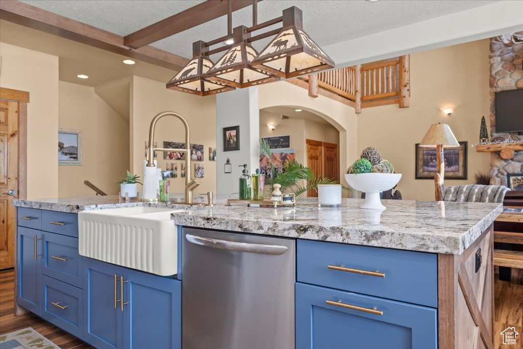 Kitchen with dark hardwood / wood-style flooring, a textured ceiling, dishwasher, light stone countertops, and a kitchen island