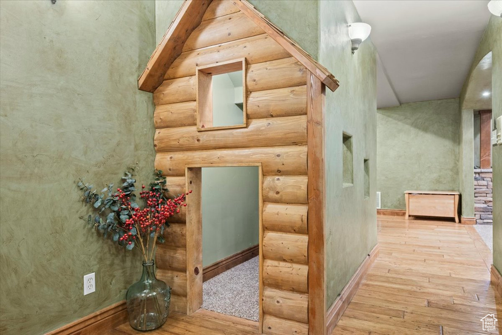 Bonus room featuring rustic walls and light hardwood / wood-style flooring