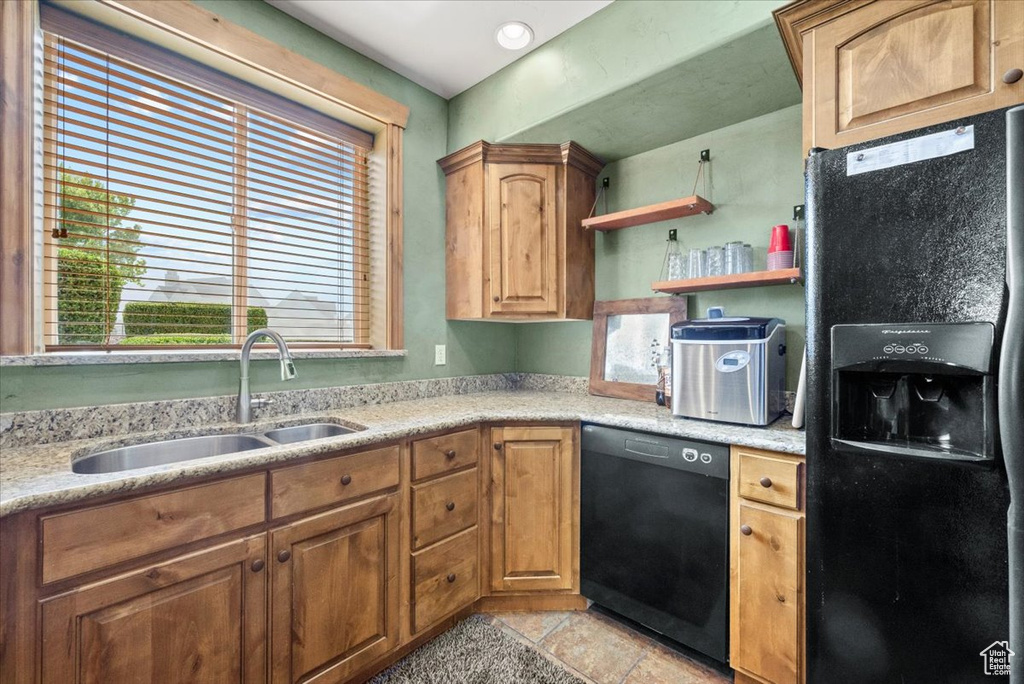 Kitchen featuring black appliances, sink, and light tile patterned floors