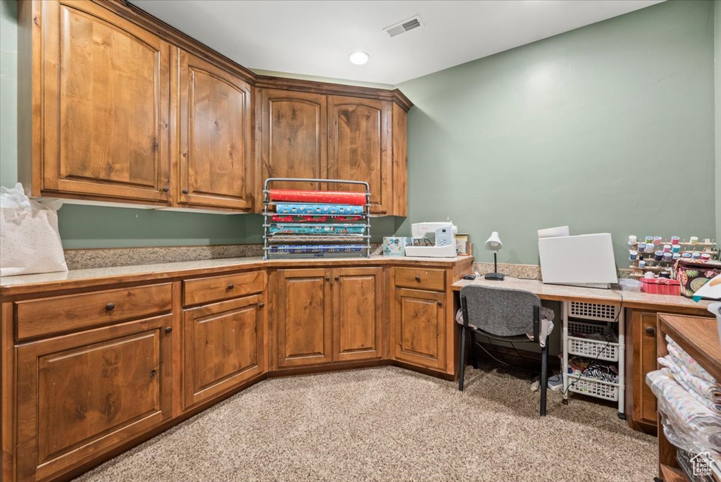 Carpeted home office with built in desk