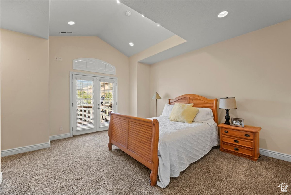 Carpeted bedroom featuring lofted ceiling and access to outside