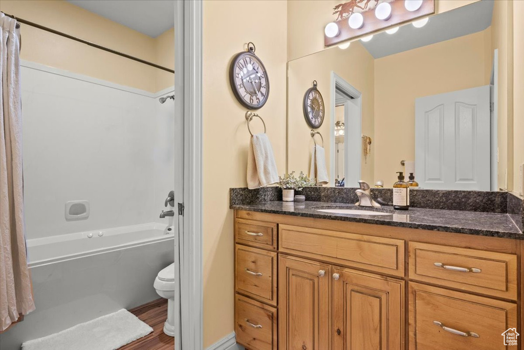 Full bathroom with shower / tub combo, vanity, and toilet