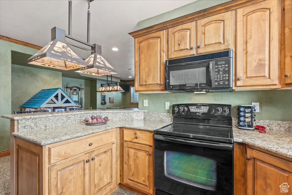 Kitchen with kitchen peninsula, hanging light fixtures, black appliances, and light stone countertops