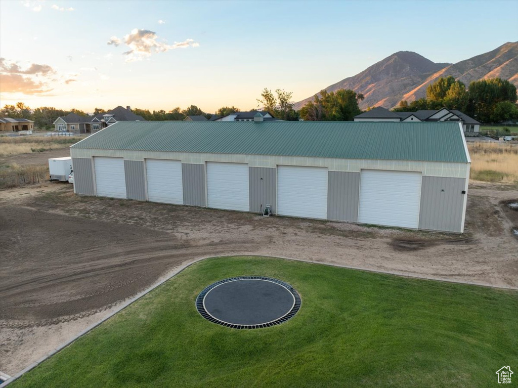 Garage at dusk with a lawn and a mountain view