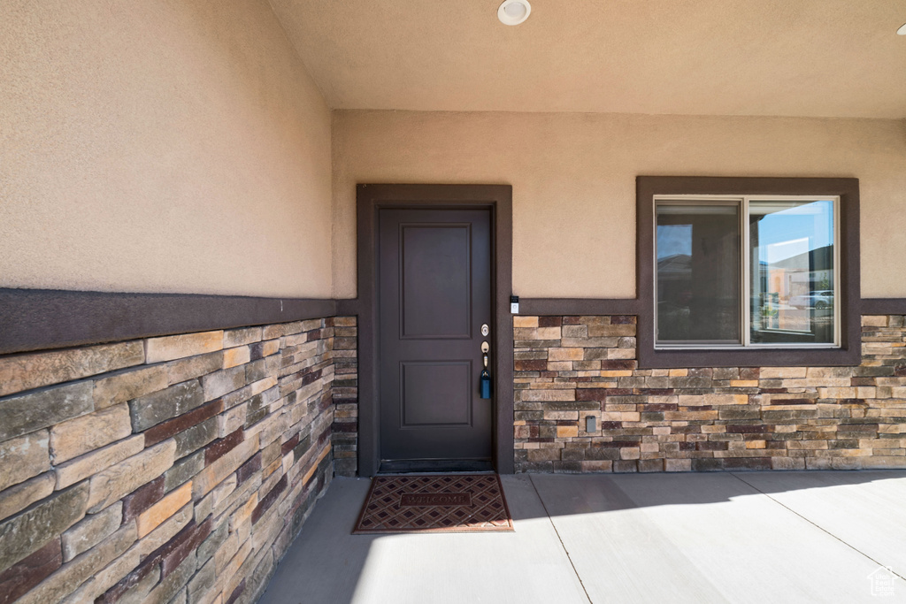 View of exterior entry with a patio area