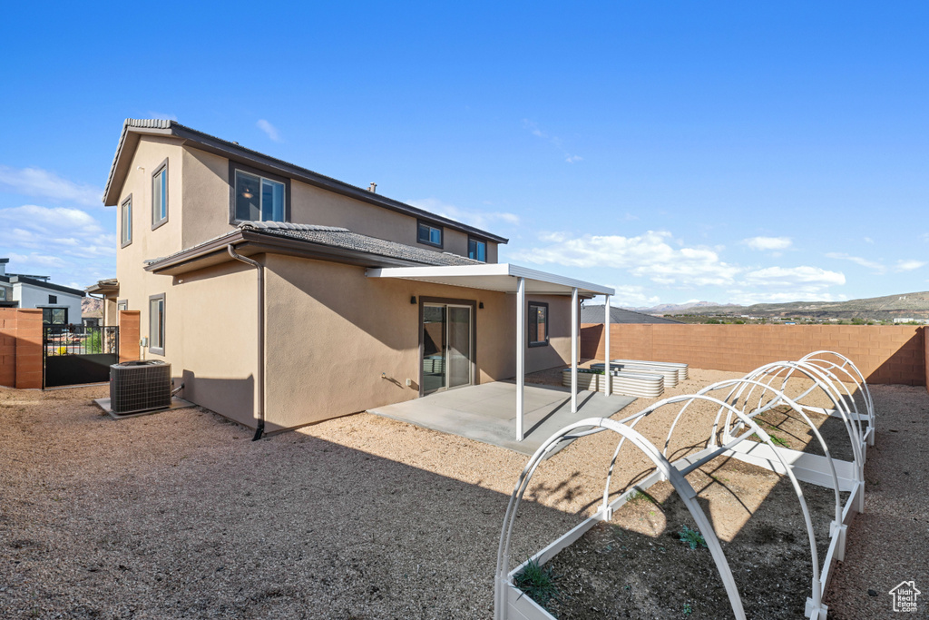 Back of house with central air condition unit and a patio area