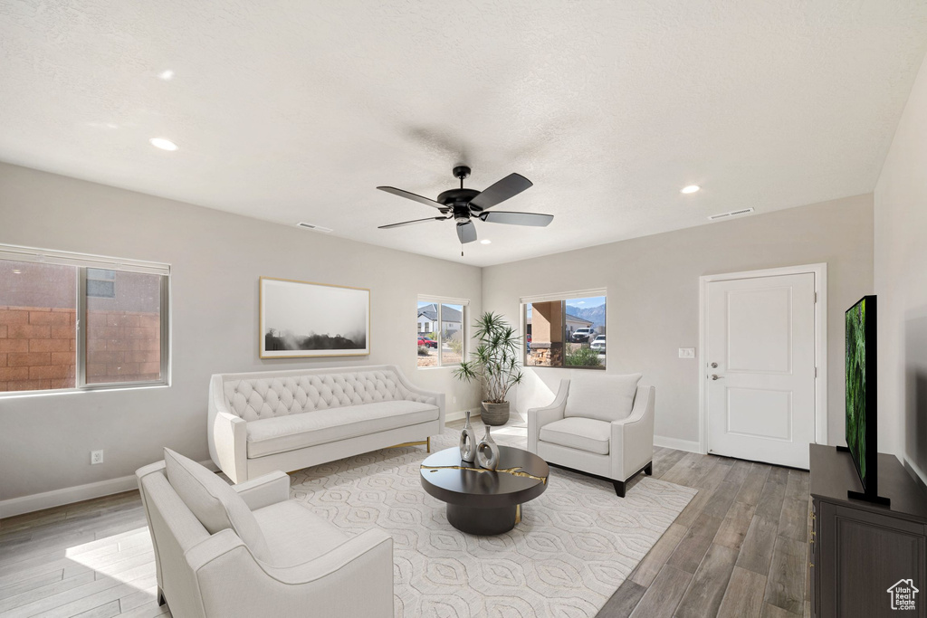 Living room with light hardwood / wood-style flooring and ceiling fan