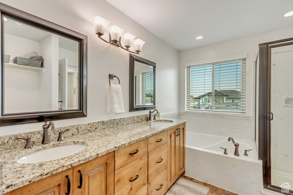 Bathroom featuring tile patterned floors, double sink vanity, and a bath