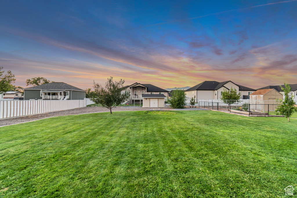 Yard at dusk featuring a garage