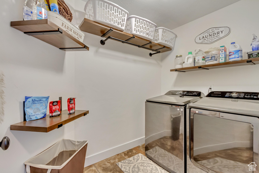 Laundry area featuring washer and clothes dryer and light tile patterned floors