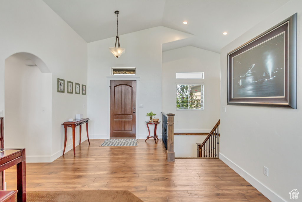 Entrance foyer with hardwood / wood-style flooring and vaulted ceiling