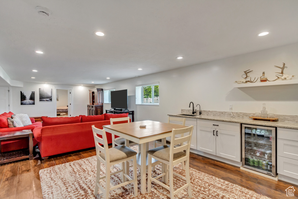 Dining area featuring sink, hardwood / wood-style flooring, and wine cooler