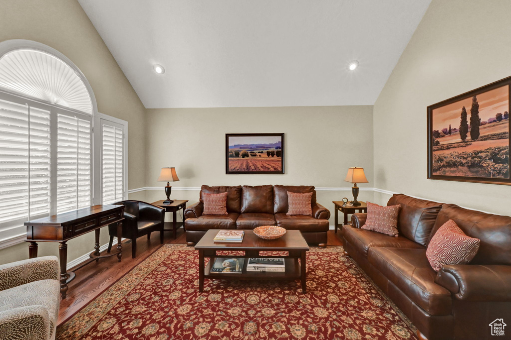 Living room featuring hardwood / wood-style flooring and high vaulted ceiling