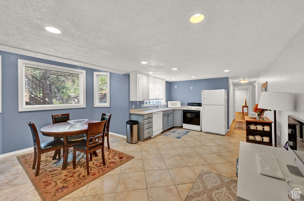 Interior space with light tile patterned flooring, sink, and a textured ceiling