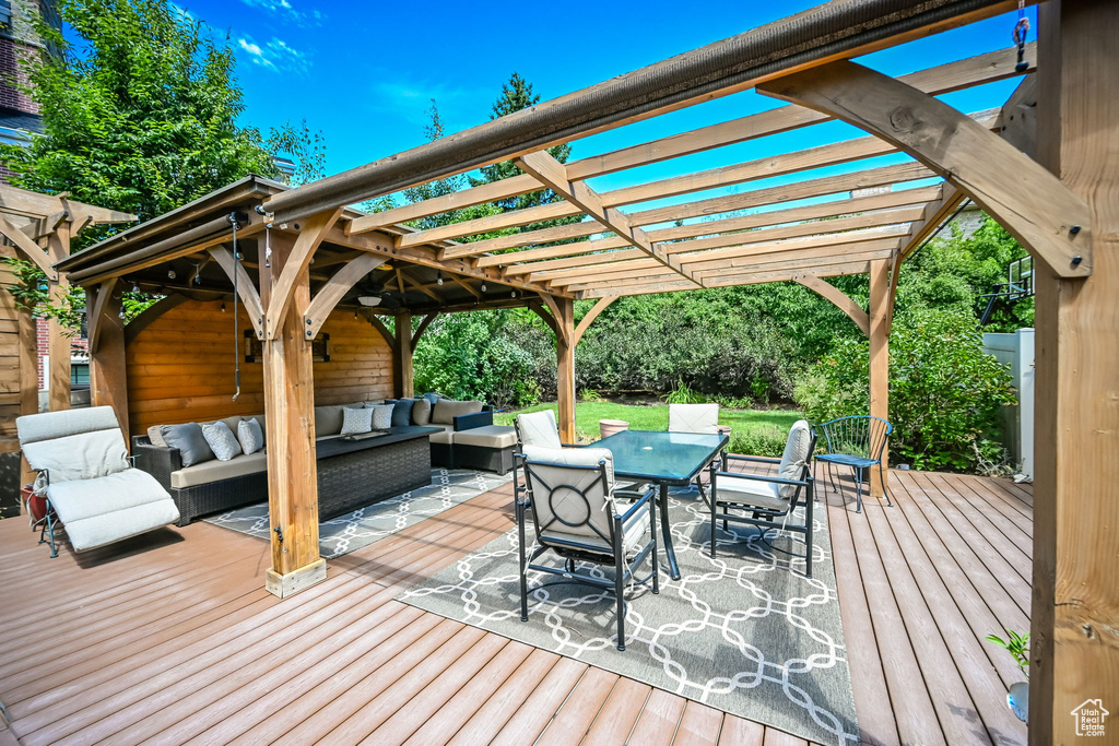 Wooden deck with a pergola and an outdoor living space