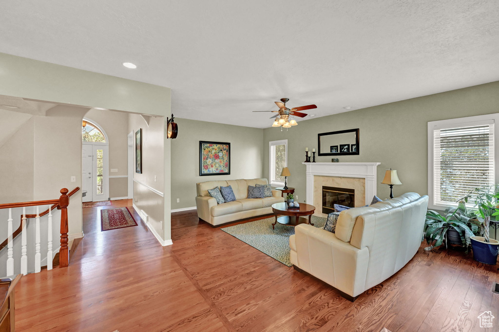 Living room with ceiling fan and hardwood / wood-style floors