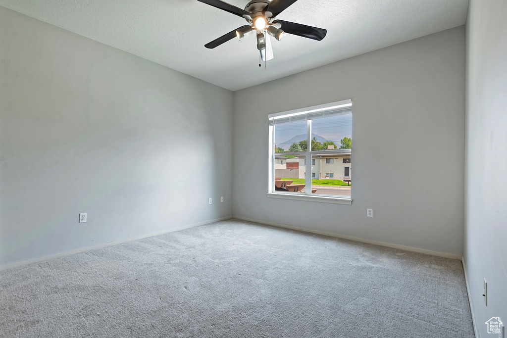 Carpeted spare room with ceiling fan