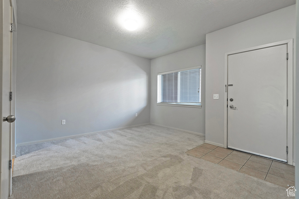 Carpeted entryway featuring a textured ceiling