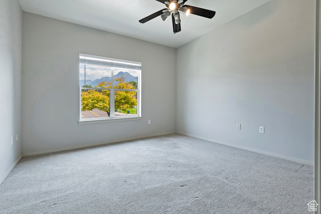 Spare room featuring carpet flooring and ceiling fan