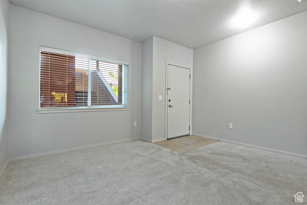 Carpeted spare room with a textured ceiling