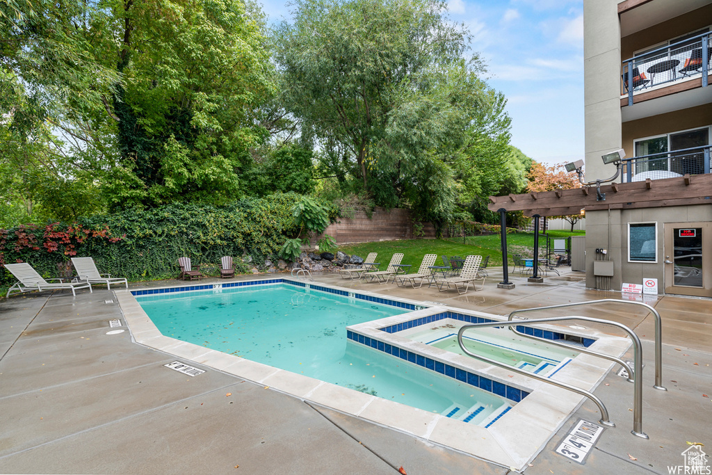 View of pool featuring a pergola, a community hot tub, and a patio area