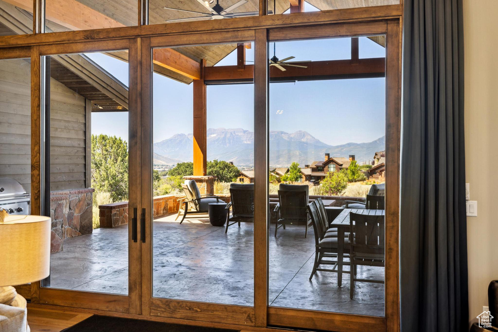 Entryway with lofted ceiling, a mountain view, and ceiling fan