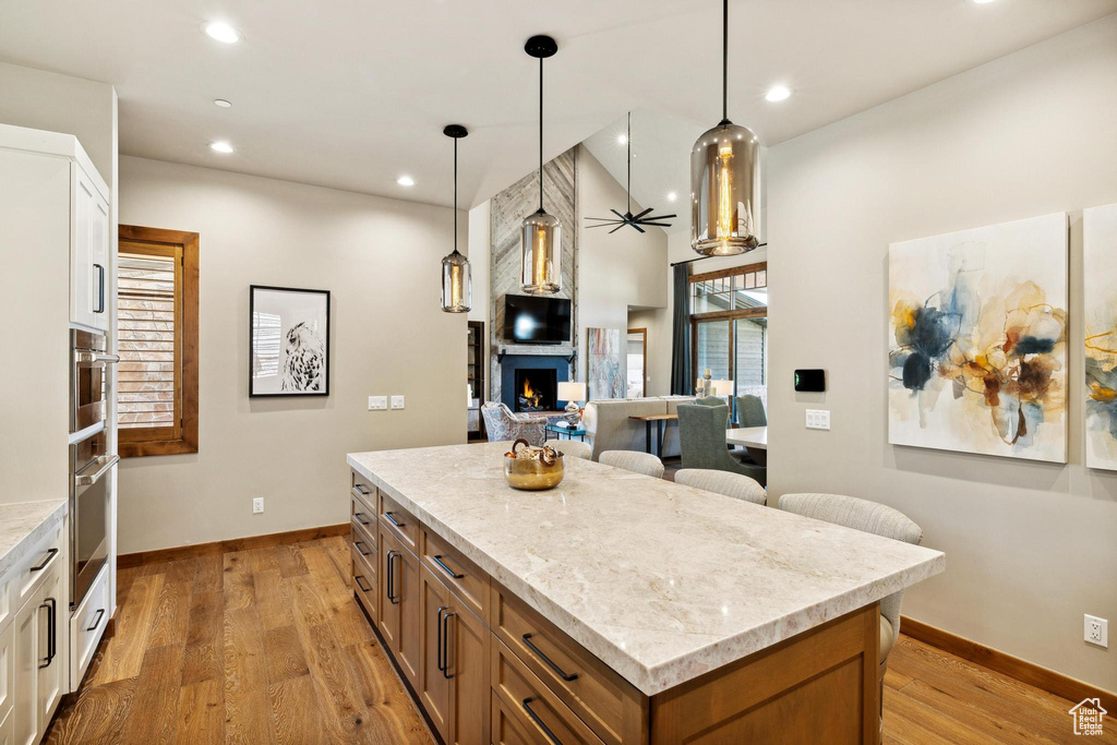 Kitchen featuring white cabinets, light hardwood / wood-style flooring, and a kitchen island